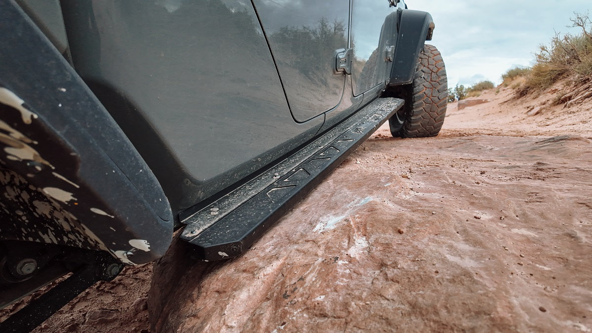 ASFIR 4x4 heavy-duty steel rock sliders installed on a Toyota 4Runner on rocky off-road terrain